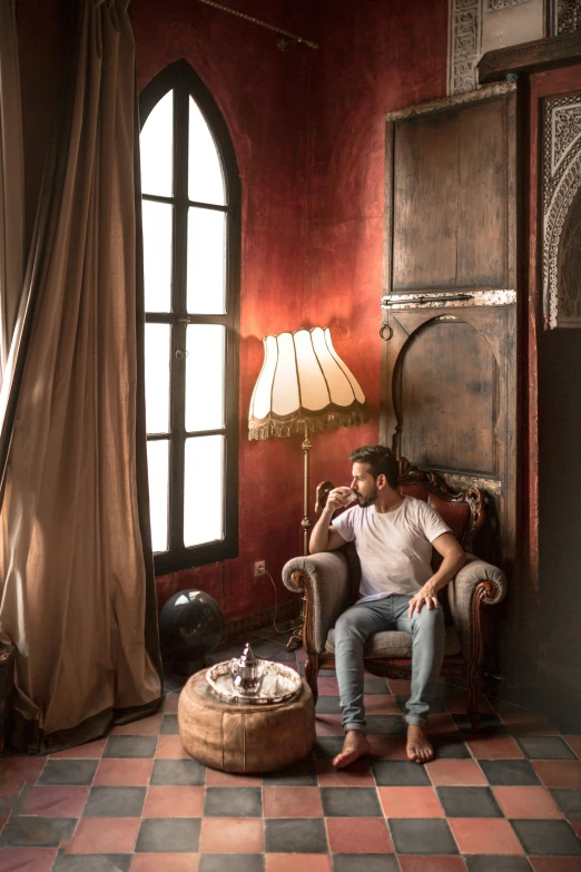 a man sitting in a chair in a room, inspired by Riad Beyrouti, renaissance, cigars, natural light in room, profile image