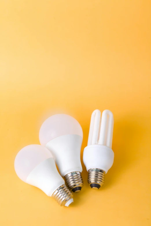 three white light bulbs on a yellow background, a picture, by Andries Stock, shutterstock, light and space, led lamps, sensors, various sizes, electric orange glowing lights