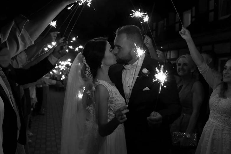 a bride and groom kiss while holding sparklers, a black and white photo, by Adam Marczyński, romanticism, 15081959 21121991 01012000 4k, - photorealistic, instagram post, ukraine. professional photo