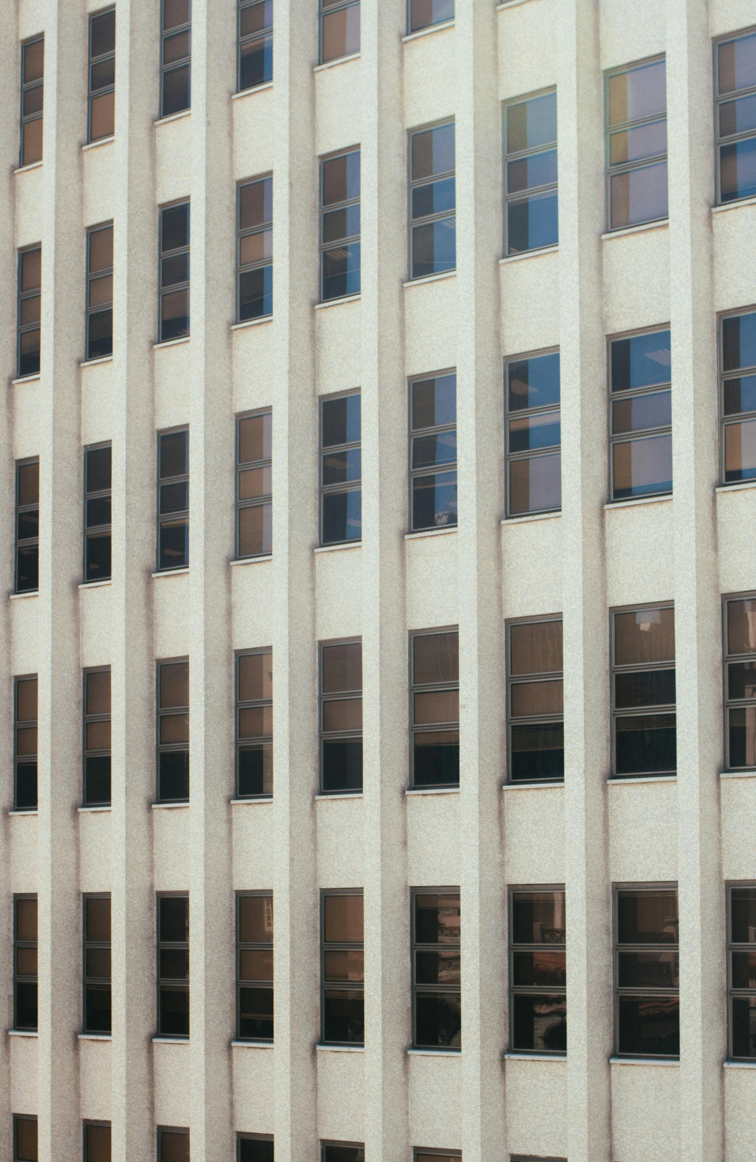 a tall white building with lots of windows, by Donald Judd, 1990s photograph, window ( city ), stalinist architecture, zoomed out shot