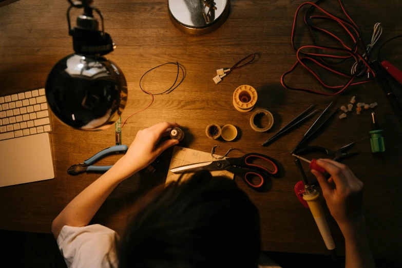 a person cutting a piece of wood with a pair of scissors, by Matthias Stom, trending on pexels, arts and crafts movement, revealing wires and electronics, avatar image, jewelry lighting, cutest