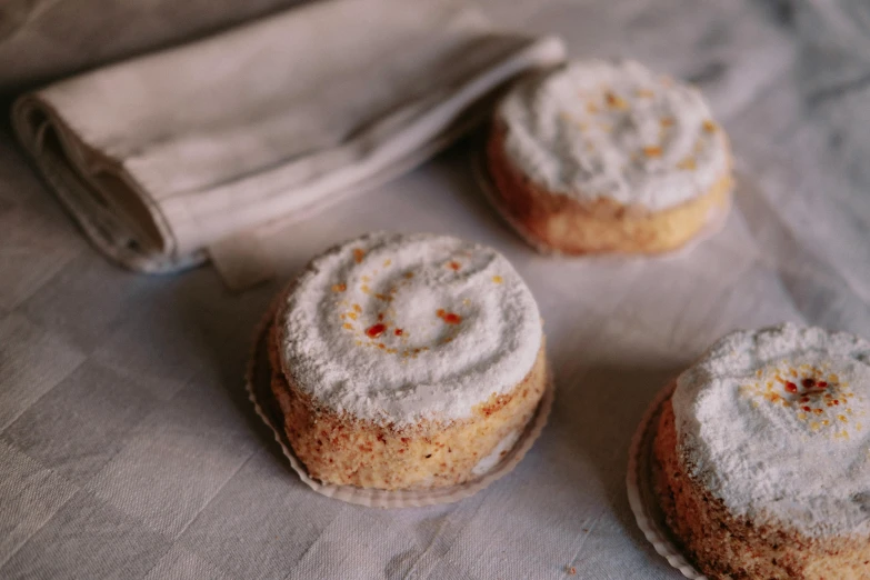 a couple of cakes sitting on top of a table, a stipple, unsplash, covered in white flour, rondel, white and orange, recipe