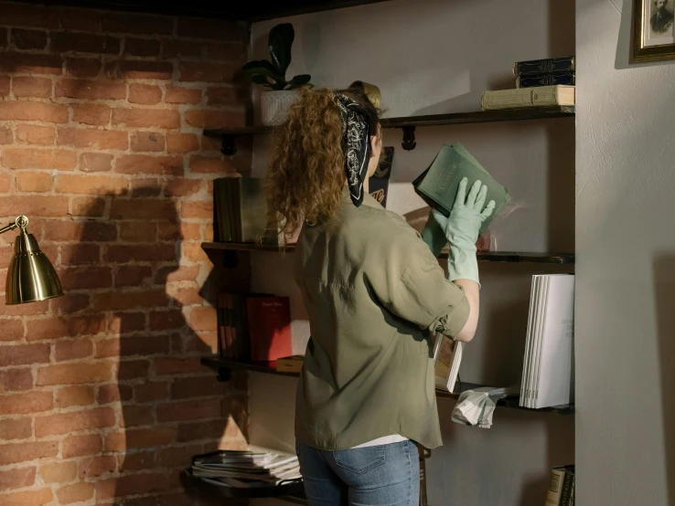 a woman standing in front of a brick wall, inspired by Pieter de Hooch, happening, shelves, worksafe. cinematic, hero prop, profile image