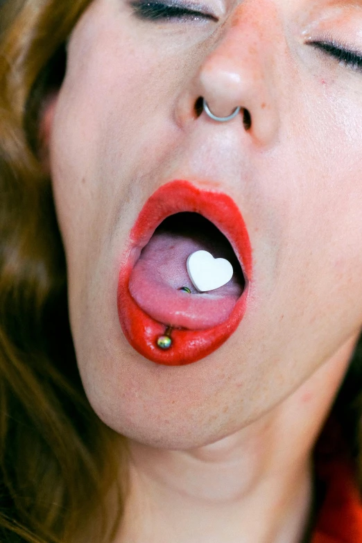 a woman taking a pill out of her mouth, an album cover, inspired by Nan Goldin, hyperrealism, heart shaped face, heavy body modification, milk bar magazine, full body shot close up