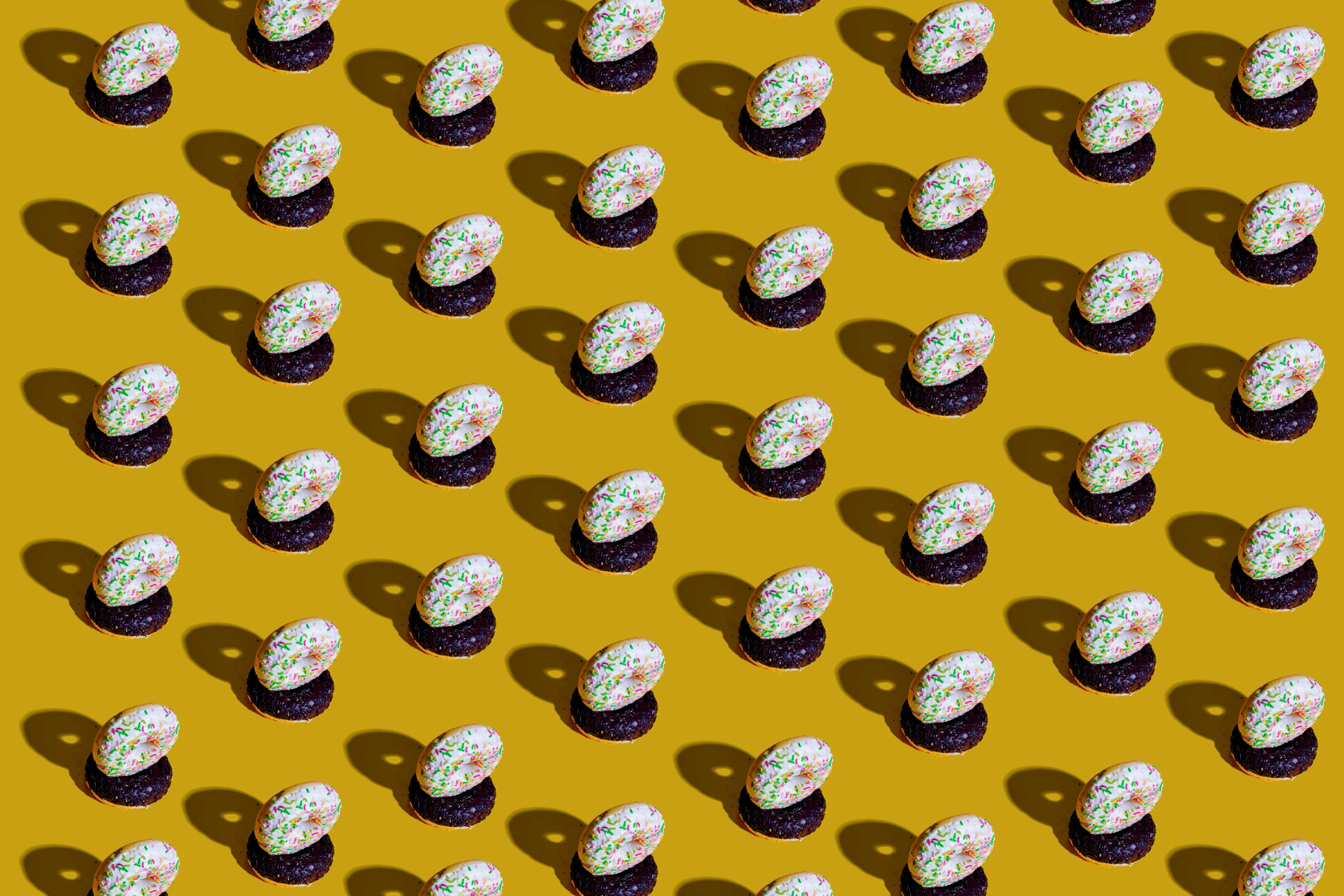 a group of cupcakes with sprinkles on them, a digital rendering, inspired by Damien Hirst, pexels, pop art, yellow wallpaper, repeating pattern, ornate egg, ffffound