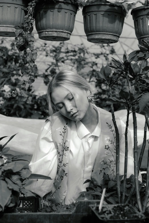 a black and white photo of a woman in a greenhouse, inspired by jeonseok lee, young blonde woman, resting, gongbi, promotional image