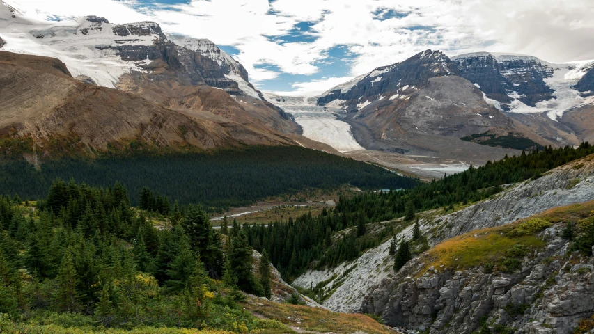 a view of a valley with mountains in the background, by Doug Wildey, pexels contest winner, glacier, slide show, brown, wide high angle view