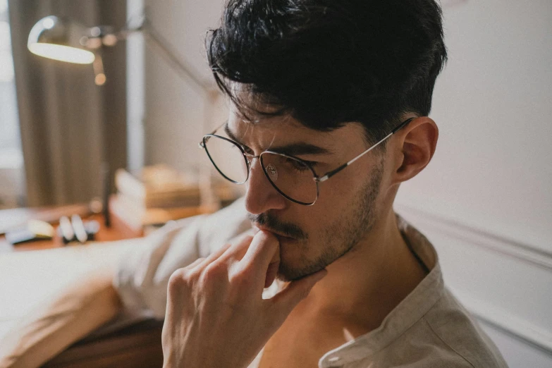 a man sitting in front of a laptop computer, trending on pexels, square rimmed glasses, seductive gaze, profile image, shaven stubble