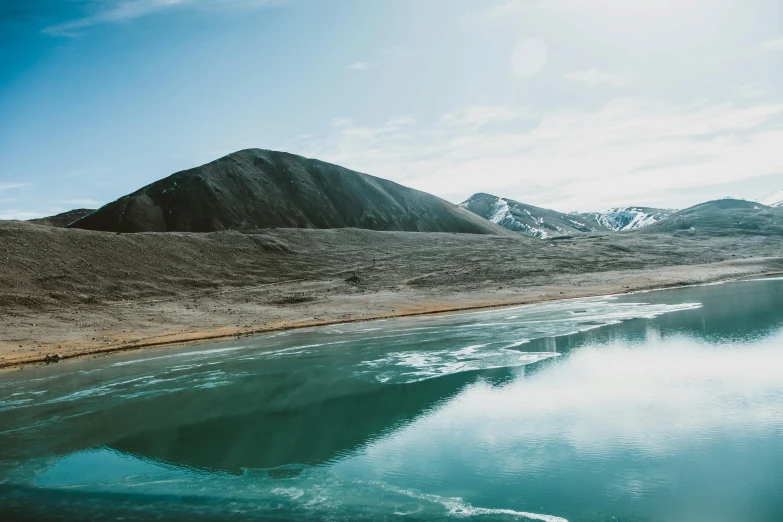 a body of water with a mountain in the background, by Julia Pishtar, pexels contest winner, hurufiyya, north pole, erosion algorithm landscape, ponds of water, mountains of ice cream