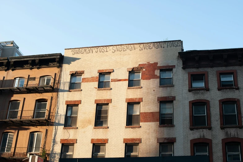a couple of buildings that are next to each other, inspired by Sidney Simon, unsplash, graffiti, harlem, ignant, stephen shore, morning sunlight
