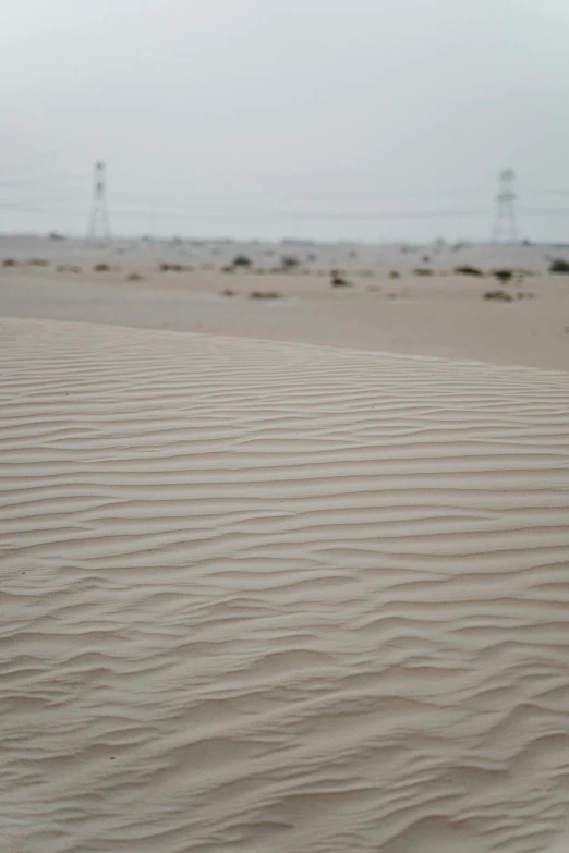 a man riding a skateboard on top of a sandy beach, dau-al-set, heavy lines, seen from afar, ameera al taweel, wet climate