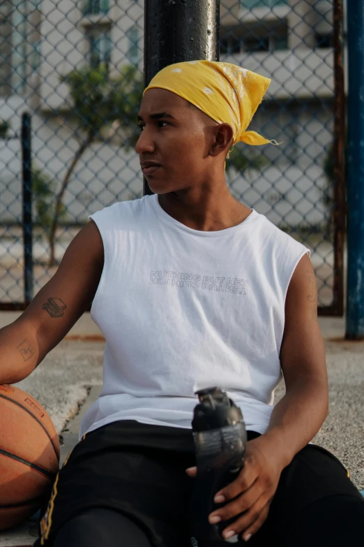 a man sitting on the ground holding a basketball, wearing : tanktop, tomboy, perez fabian, profile image