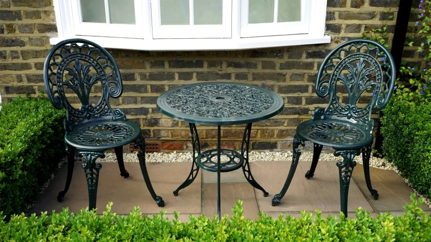 a table and two chairs in front of a window, inspired by Elizabeth Shippen Green, pexels, ornate iron armour, suburban garden, wide high angle view, upscaled to high resolution