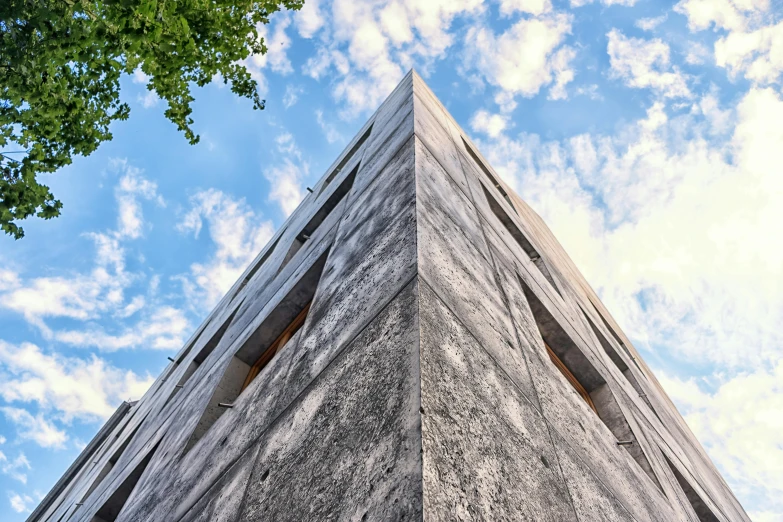 a tall building with a clock on the top of it, inspired by Peter Zumthor, pexels contest winner, brutalism, gray stone wall, angular face, low angle 8k hd nature photo, heavenly marble