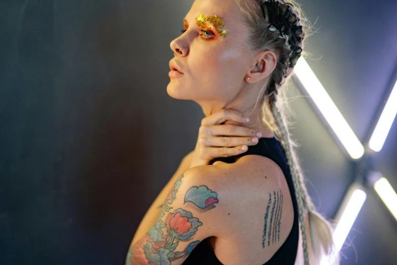 a woman with a tattoo on her arm, inspired by Louisa Matthíasdóttir, trending on pexels, gold bodypaint, portrait of annasophia robb, undercut hairstyle, coloured photo