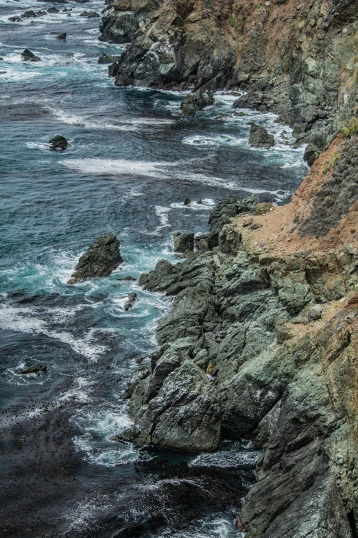 a train traveling along the side of a cliff next to the ocean, gigapixel photo, central california, detailed 4k photograph, highly turbulent