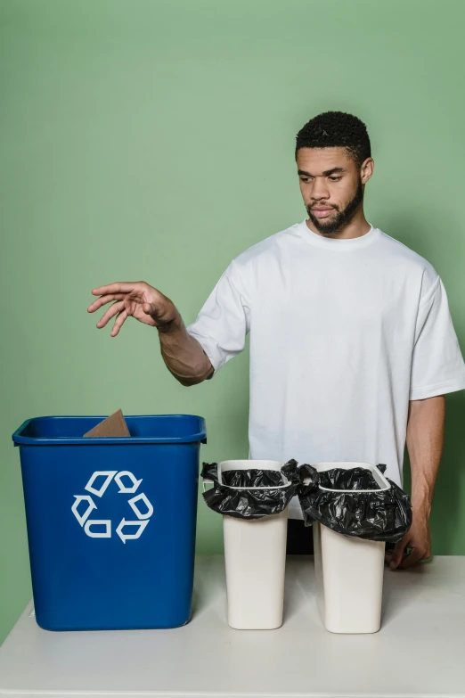 a man standing in front of two trash cans, ripped fabric, sustainability, ecommerce photograph, black man