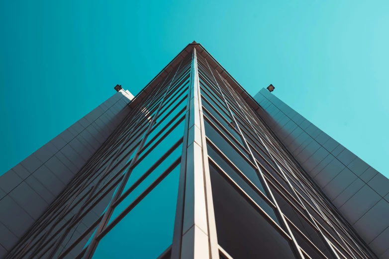 a tall building with a blue sky in the background, unsplash, square lines, intricate image, sharp angles, absolutely outstanding image