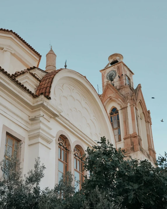 a large white building with a clock tower, unsplash contest winner, neoclassicism, cyprus, profile image, domes, building cover with plant