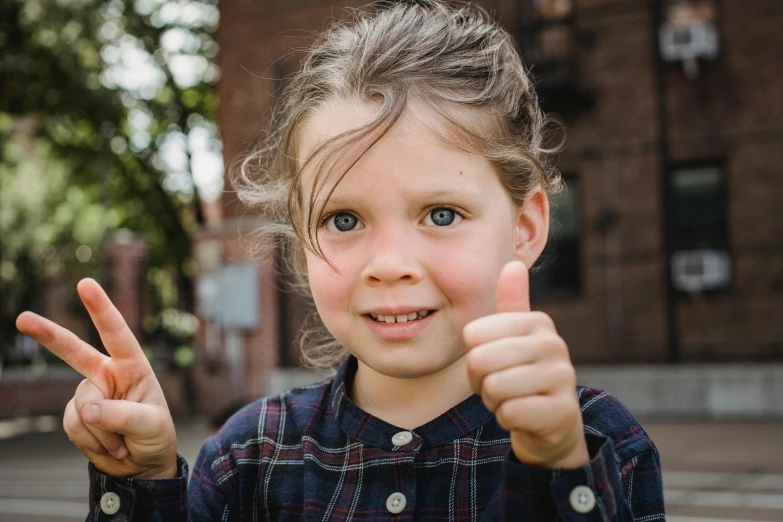 a little girl making a peace sign with her fingers, pexels contest winner, giving a thumbs up to the camera, max dennison, 🤤 girl portrait, private school