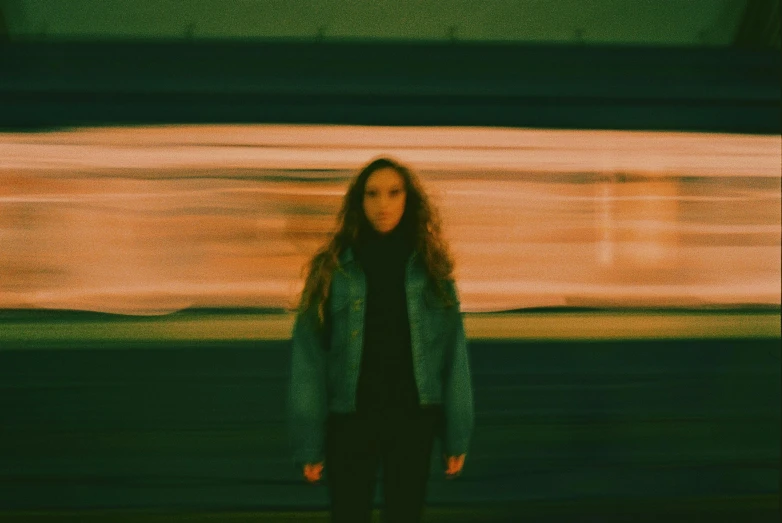 a woman with long hair standing in front of a train, a picture, by Emma Andijewska, vhs effects, portrait featured on unsplash, muted lights, vapourwave