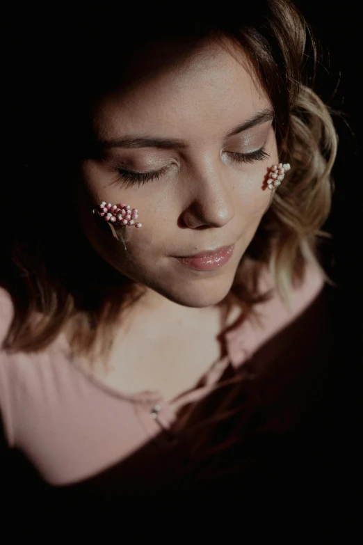 a close up of a person holding a cell phone, an album cover, inspired by Elsa Bleda, antipodeans, sakura petals around her, spotlight in middle of face, press shot, looking down