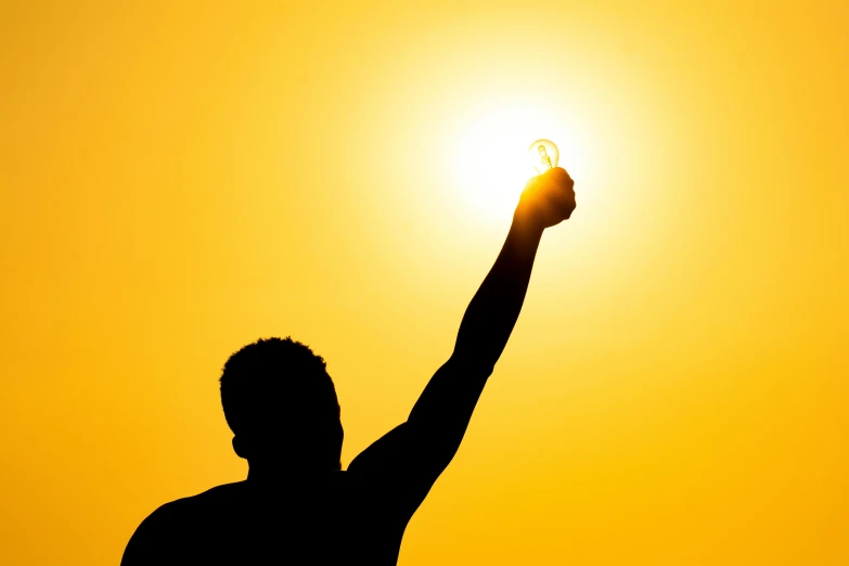 a silhouette of a man holding up a light bulb, pexels contest winner, hot summer sun, showing victory, light skin, rectangle