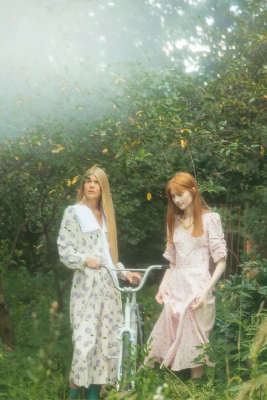 a couple of women standing next to each other, an album cover, inspired by Elsa Bleda, pre-raphaelitism, bicycle, long strawberry - blond hair, ulzzang, cottagecore!! fitness body