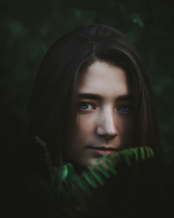 a woman holding a fern leaf in front of her face, a character portrait, inspired by Elsa Bleda, unsplash contest winner, dark green eyes, 🤤 girl portrait, portrait of arya stark, color photograph portrait 4k