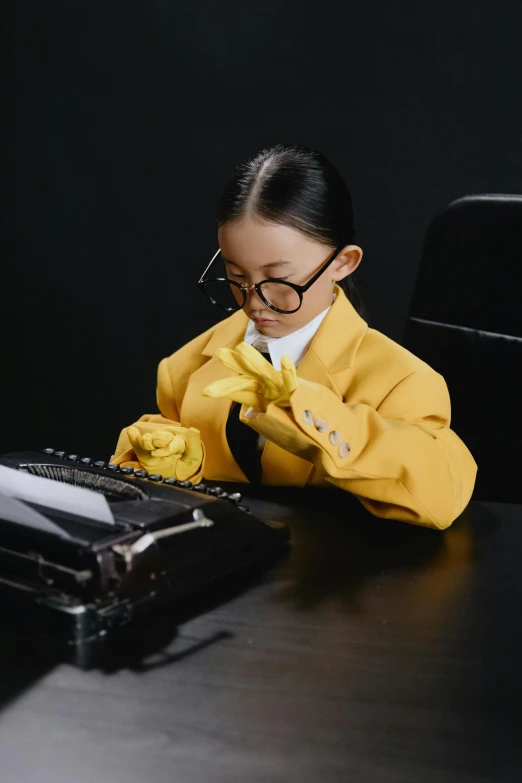 a little girl sitting at a table with a keyboard, inspired by Min Zhen, pexels contest winner, process art, yellow latex gloves, wearing a strict business suit, inspect in inventory image, asian women