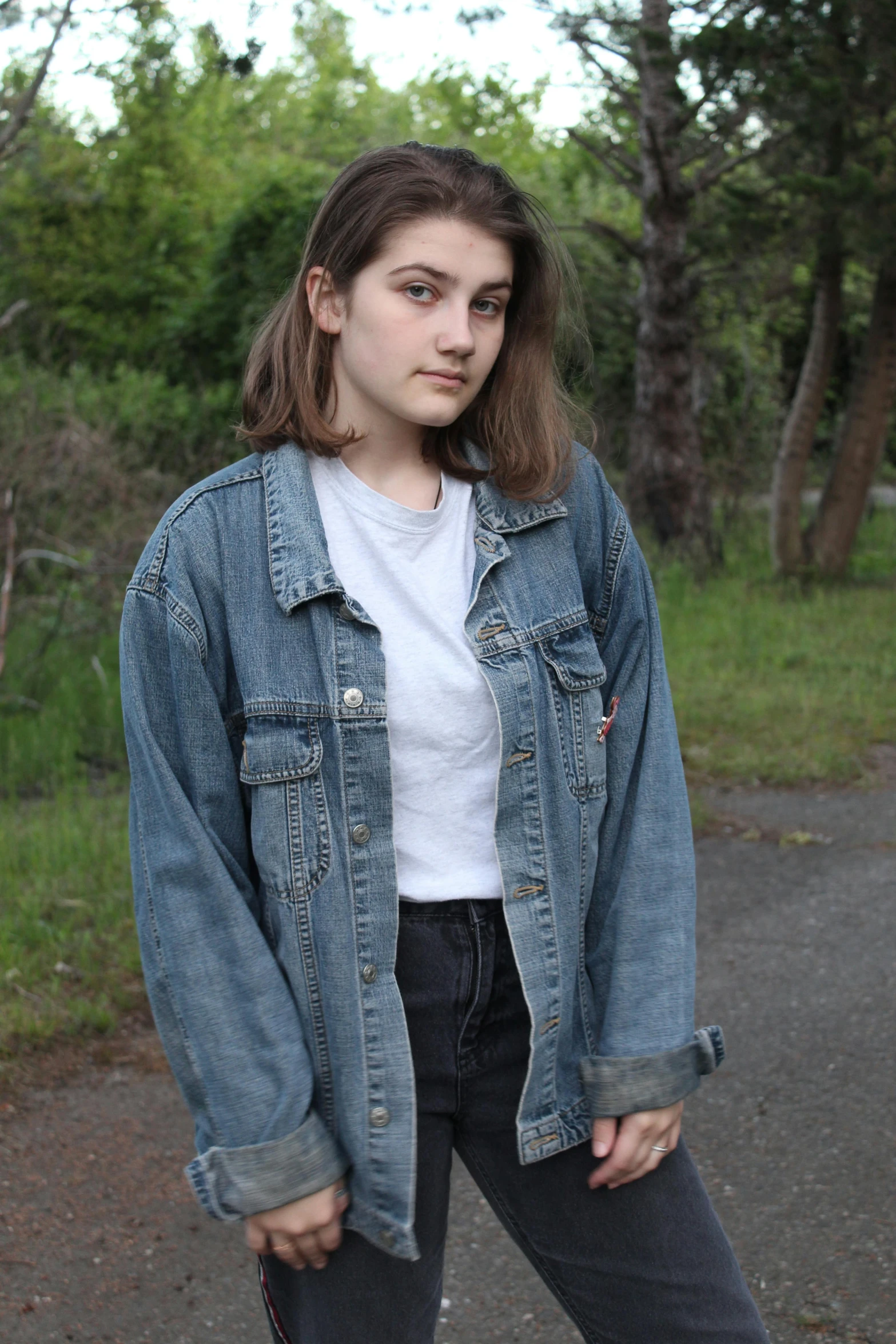 a young woman standing on top of a skateboard, an album cover, inspired by Elsa Bleda, unsplash, realism, denim jacket, (12x) extremely pale white skin, 🤤 girl portrait, beautiful grumpy girl
