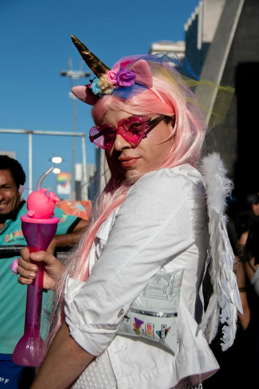 a woman with pink hair wearing a unicorn costume, 2011 comic-con, holding a wand, in the sun, chile