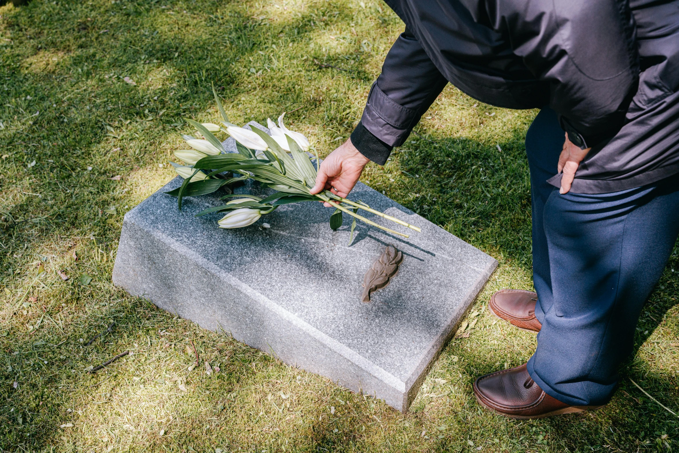 a man placing a flower on a grave, by Julia Pishtar, dead fish, grey, professionally made, graveside