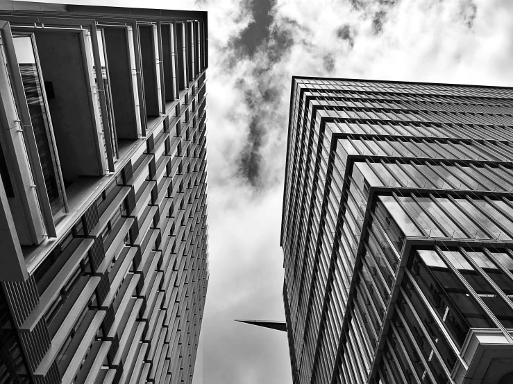 a black and white photo of two tall buildings, by Adam Rex, pexels contest winner, low angle!!!!, square, trinity, view from ground