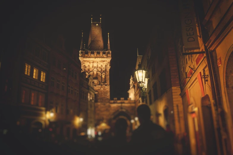 a clock tower towering over a city at night, by Adam Marczyński, pexels contest winner, renaissance, people walking around, prague, muted lights, very detailed feel