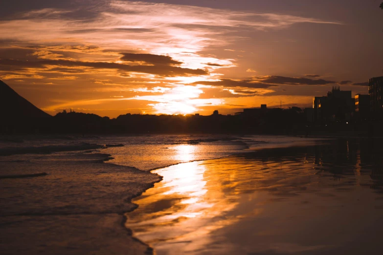 the sun is setting over the water on the beach, pexels contest winner, brown, liquid gold, surrounding the city, australian beach