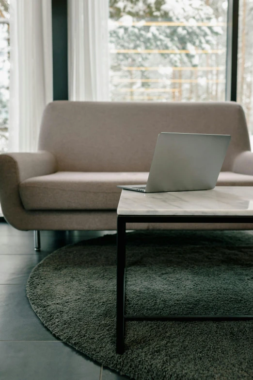 a laptop sitting on top of a table in a living room, unsplash, modernism, carpeted floor, marble material, brown, white