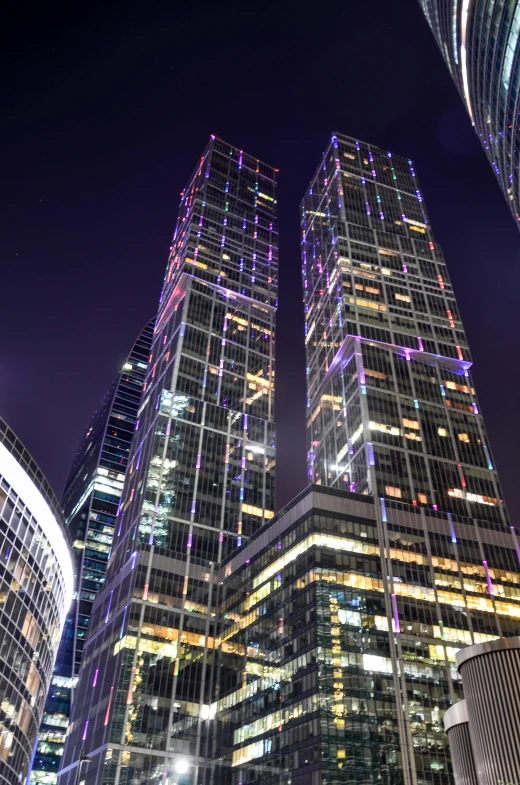 a group of skyscrapers lit up at night, in moscow centre, huge glass structure, jc park, minneapolis