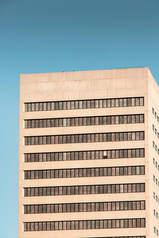 a tall building with a clock on top of it, an album cover, inspired by Robert Bechtle, unsplash, brutalism, minn, brown, clear blue skies, trending photo