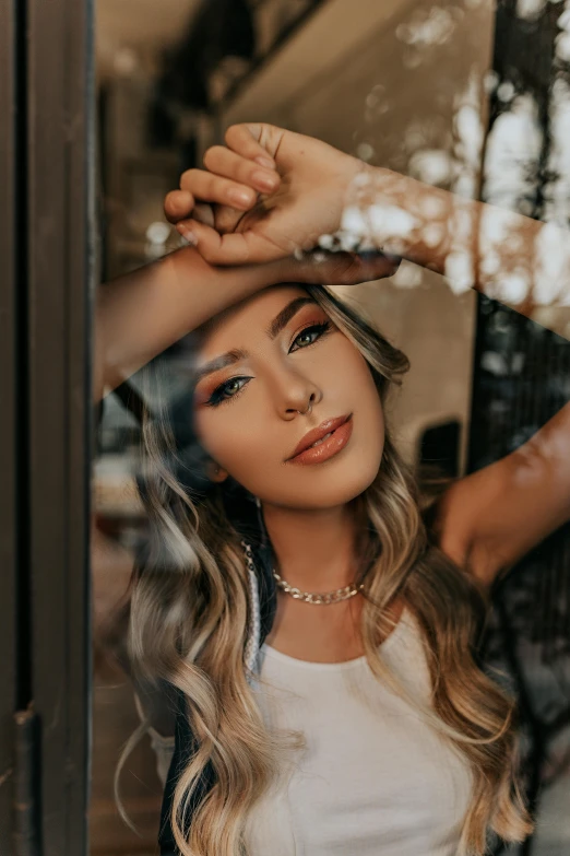 a woman standing in front of a window with her hands on her head, a picture, by Julia Pishtar, trending on pexels, madison beer girl portrait, close up of a blonde woman, wearing gold detailed choker, leaning on door