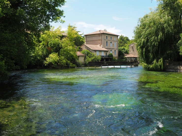 a river running through a lush green forest, les nabis, prefecture streets, crystal clear blue water, slide show, mills