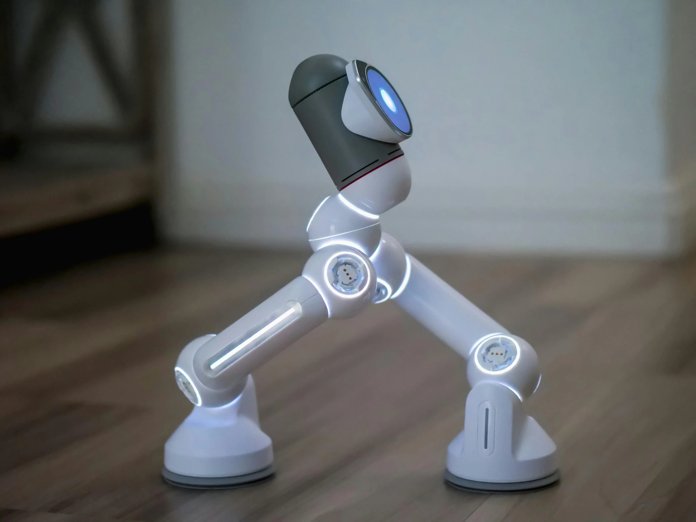 a close up of a toy robot on a wooden floor, a hologram, inspired by Pixar, unsplash, kinetic art, two arms and to legs, glowing white accent lighting, grey, hey buddy