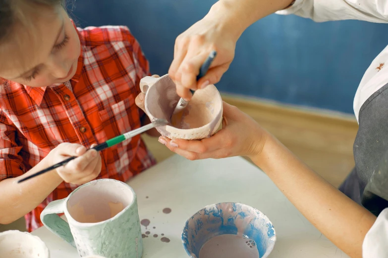 a couple of kids that are sitting at a table, inspired by Hendrik Gerritsz Pot, trending on pexels, clay material, pour paint, medium close shot, painting of an undercover cup