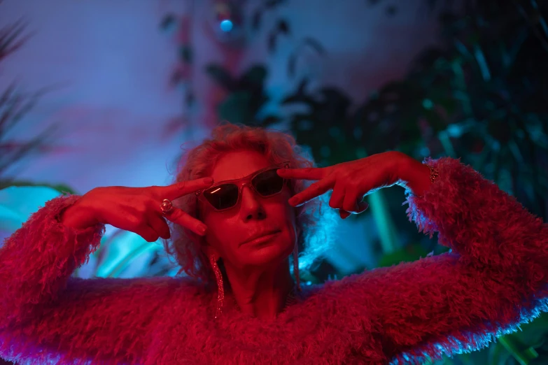 a close up of a person wearing sunglasses, inspired by Elsa Bleda, maximalism, performing a music video, soft calm warm neon atmosphere, elderly greek goddess, triumphant pose