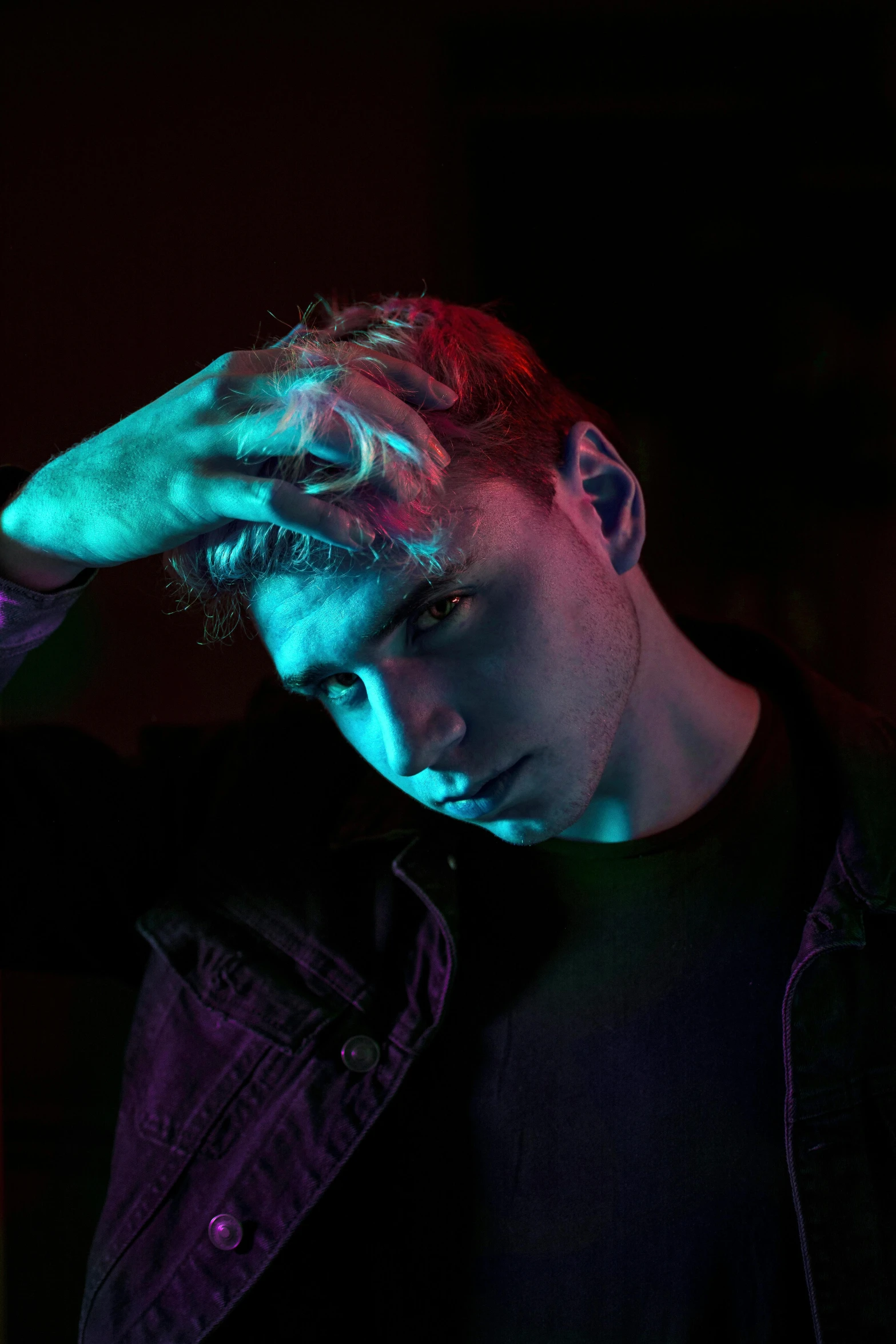 a man that is standing in the dark, an album cover, trending on pexels, non binary model, red and blue eyes, hero pose colorful city lighting, caspar david