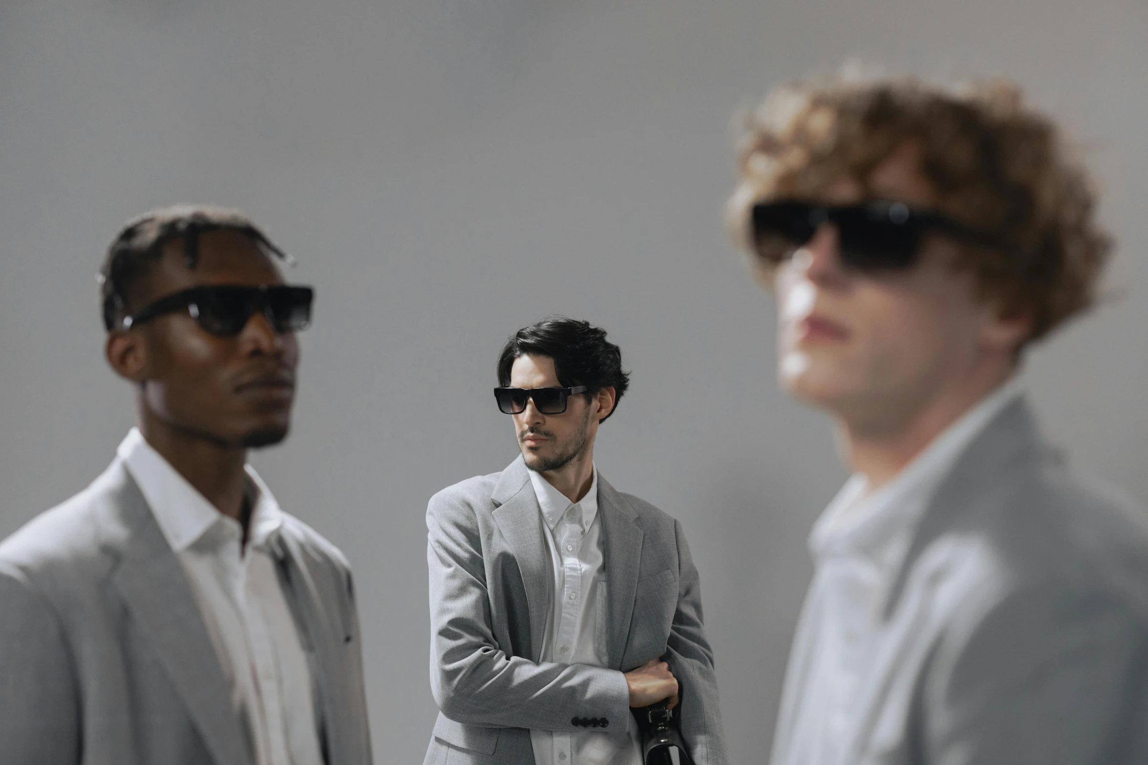 a couple of men standing next to each other, by Carey Morris, trending on pexels, bauhaus, fashion model in sunglasses, group of people, a still of an ethereal, third dimensional