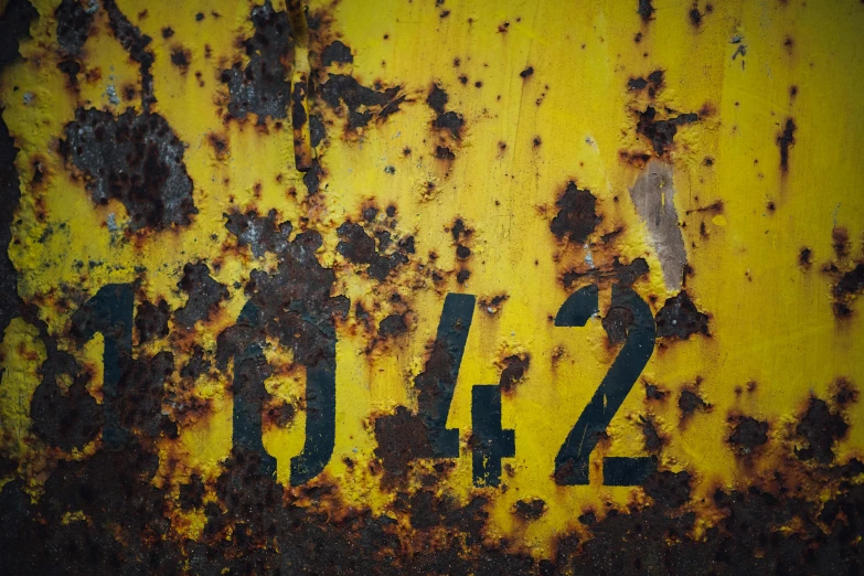 a rusted metal surface with the word blizz written on it, a photo, by Adam Chmielowski, unsplash, yellow and black color scheme, numerical, 4 2 0, square