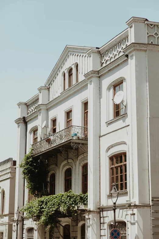 a large white building sitting on the side of a road, pexels contest winner, art nouveau, balcony, high resolution photo, mansion, neo kyiv