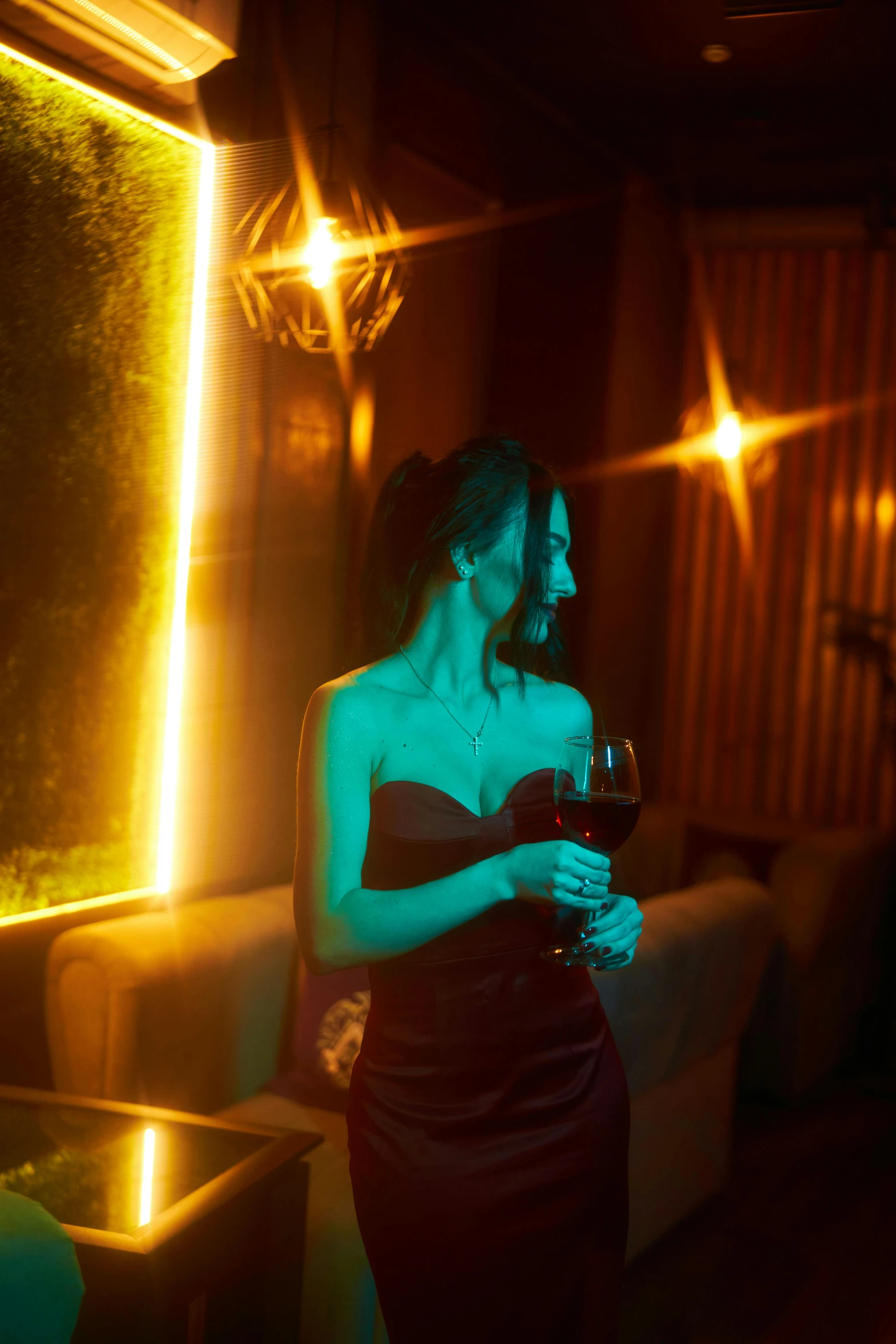 a woman in a red dress holding a glass of wine, inspired by Elsa Bleda, pexels contest winner, romanticism, neon ambient lighting, luxurious environment, pose 4 of 1 6, anna nikonova