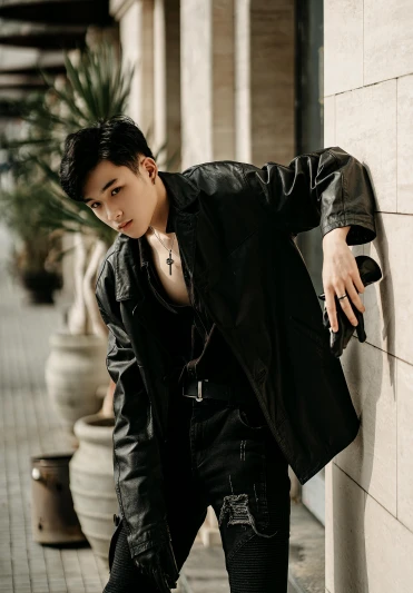 a man in a black jacket leaning against a wall, an album cover, inspired by Zhang Han, wearing a black leather vest, mai anh tran, large)}], profile pic